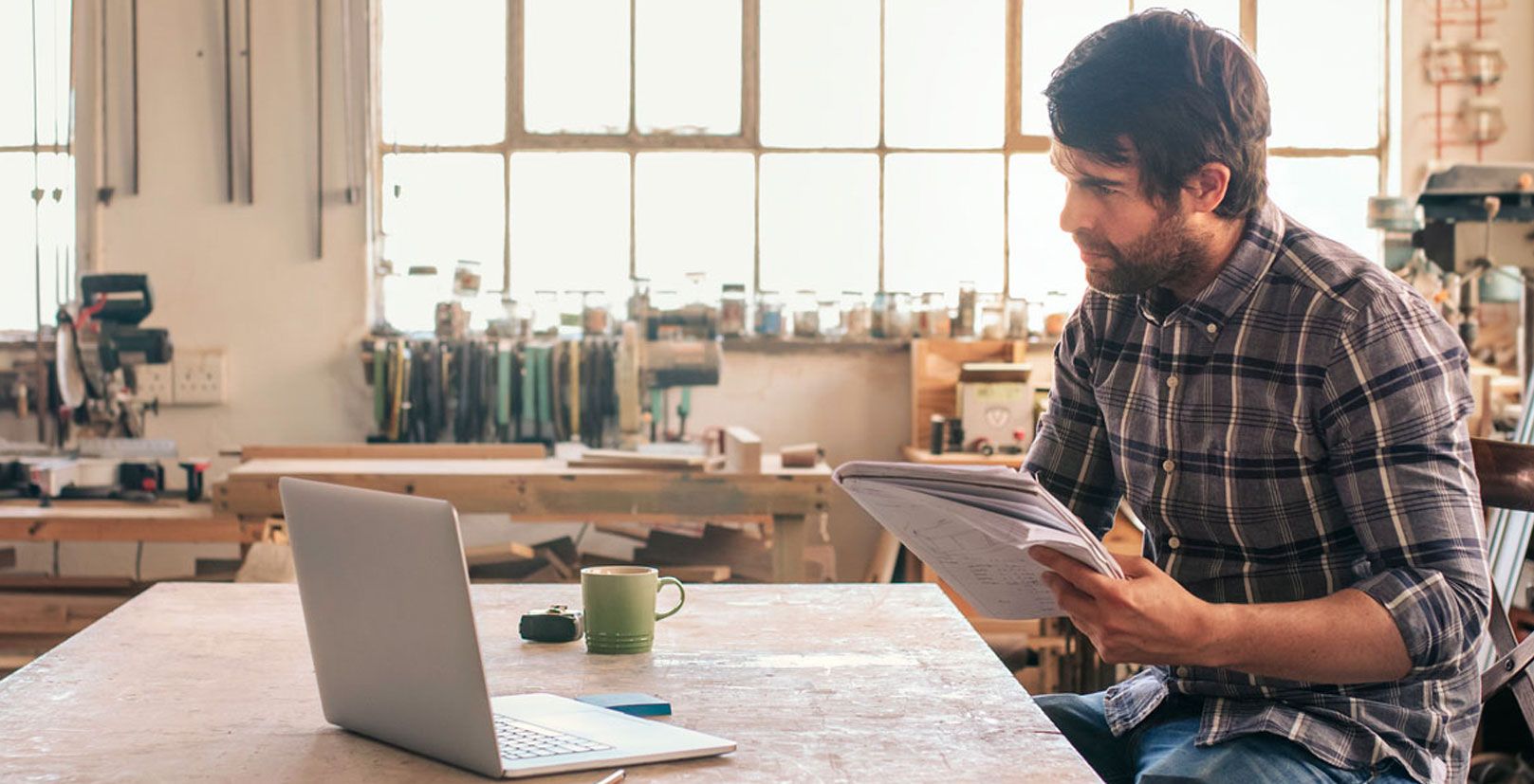 Man studying something on his laptop and making notes