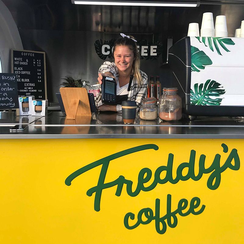 Freddy's coffee owner holding up EFTPOS machine