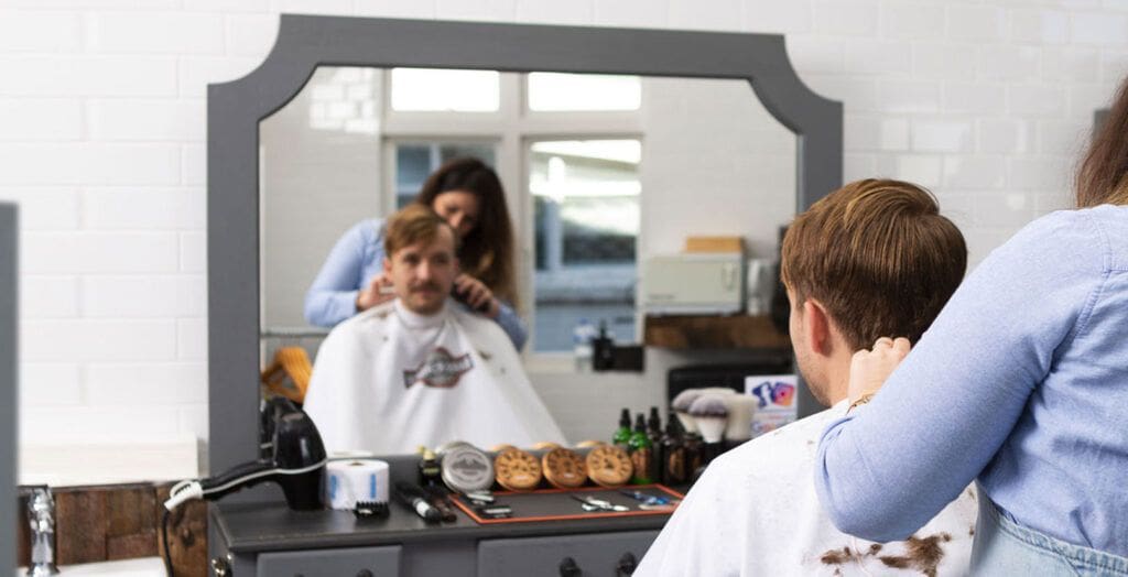 Lady cutting a mans hair