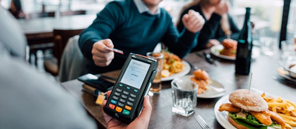Customers paying for food at restaurant table