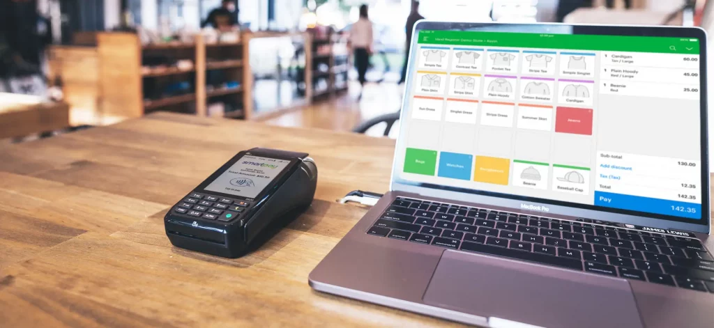 Smartpay EFTPOS machine lying next to laptop with Vend POS