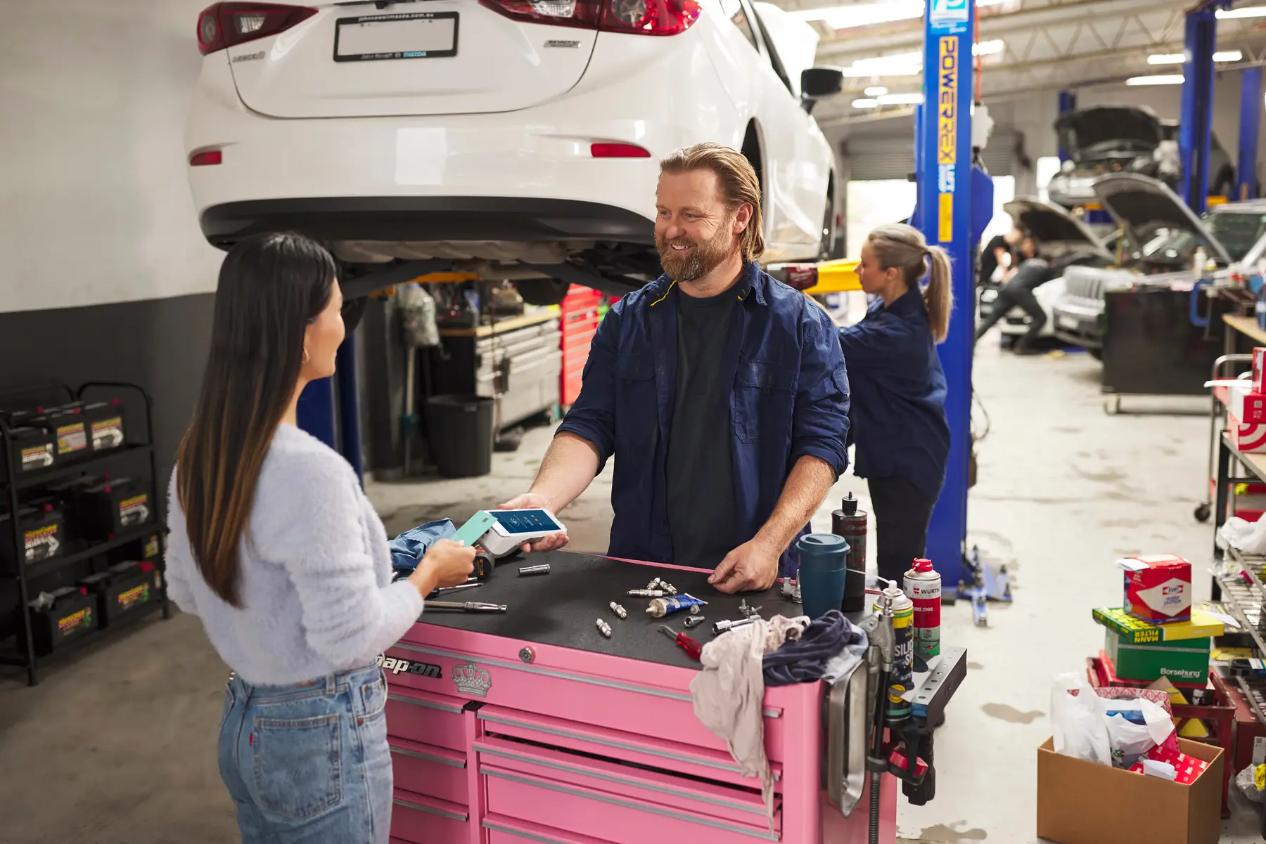 Car repair merchant accepting customer's contactless payment