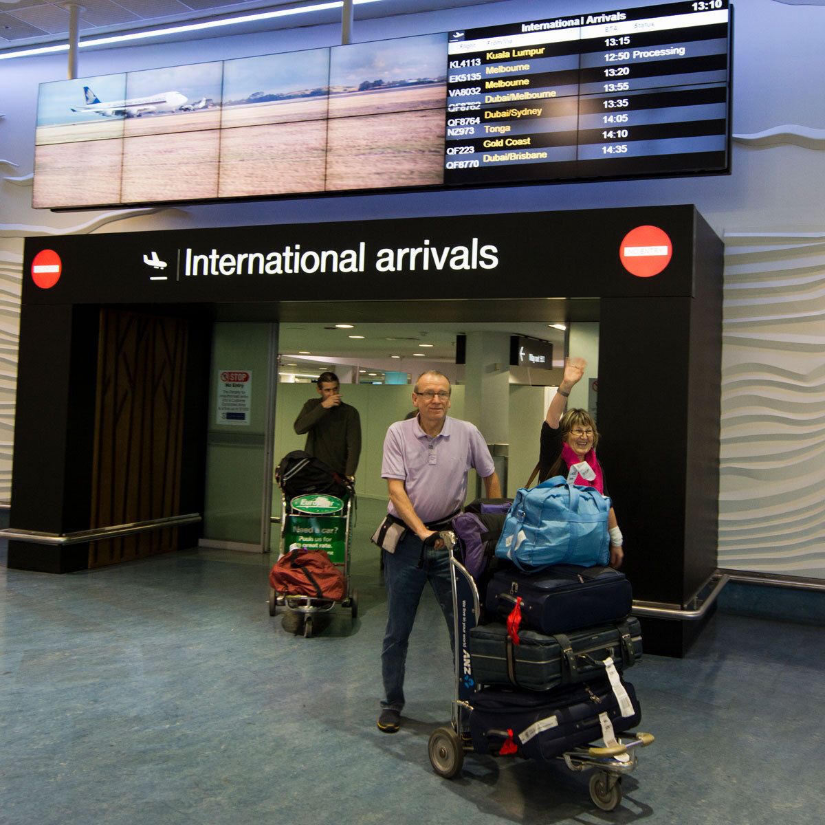 Couple arriving at Auckland airport international arrivals gate
