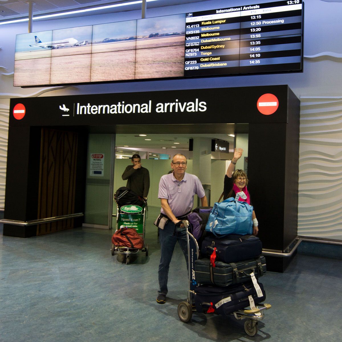 Couple arriving at Auckland airport international arrivals gate