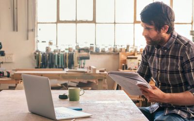 Man studying something on his laptop and making notes